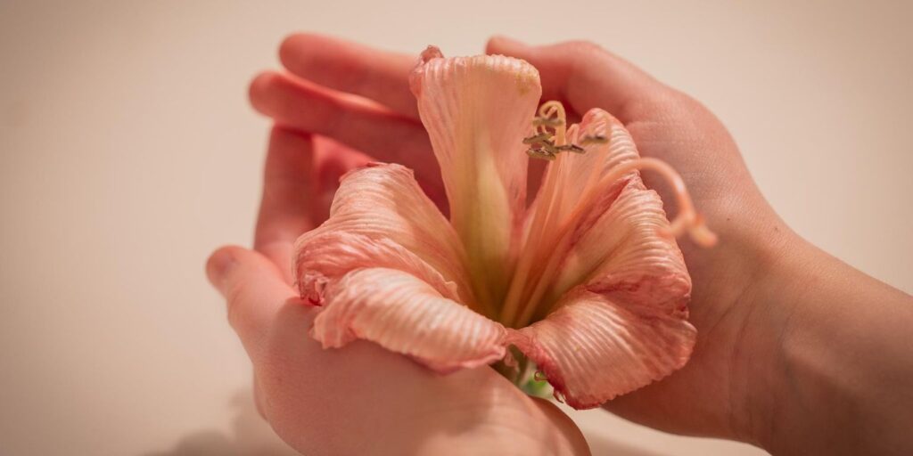Mulher segurando flor, representando flora vaginal após uso do candfemm