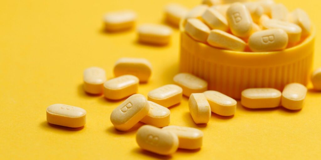 Comprimidos de vitamina B em fundo amarelo